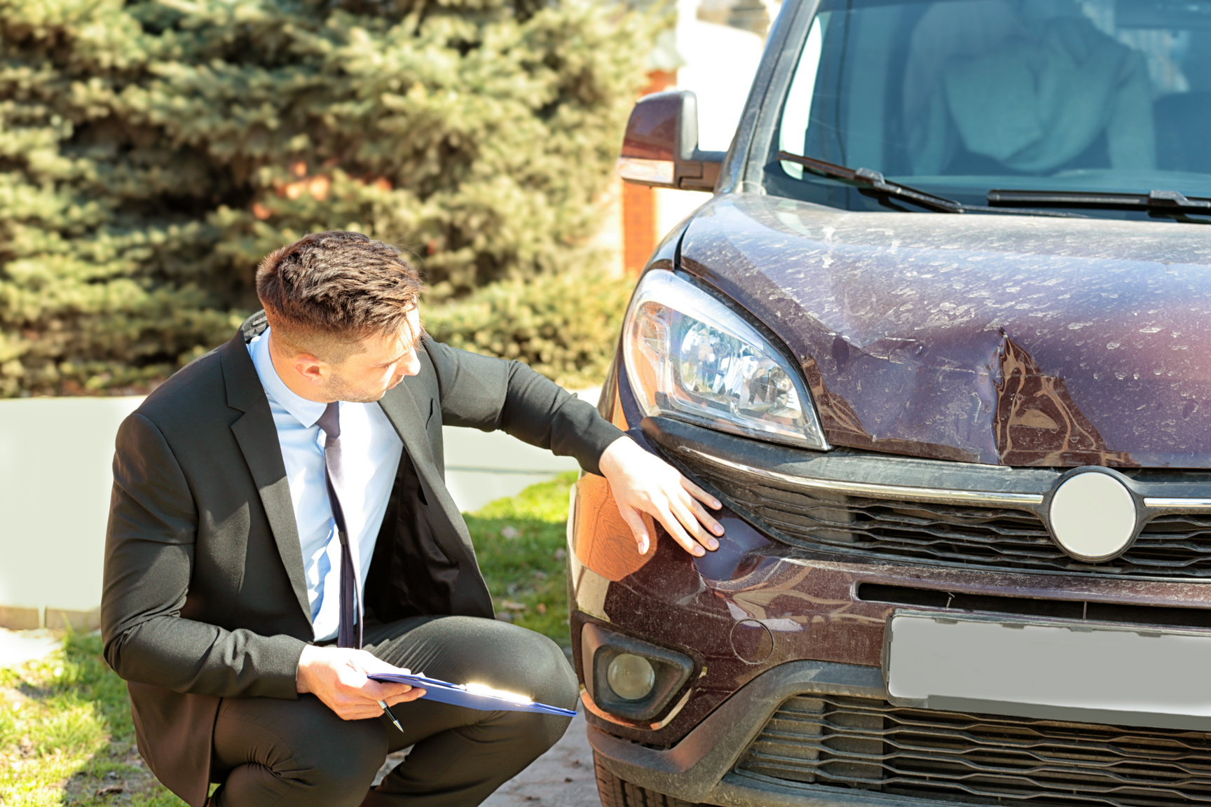Insurance Adjuster Inspecting a Car after Accident